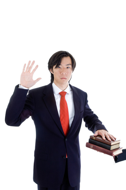 Aasialainen mies vannoo pino raamattuja eristetty valkoinen
 - Valokuva, kuva