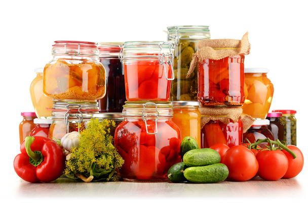 Jars with pickled vegetables and fruity compotes on white - Photo, Image