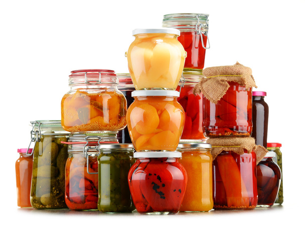 Gläser mit eingelegtem Gemüse und fruchtigen Kompotten auf weißem - Foto, Bild