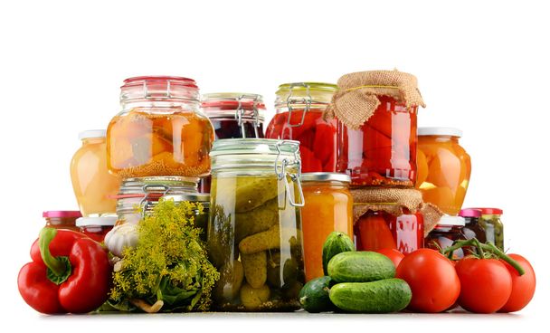 Jars with pickled vegetables and fruity compotes on white - Photo, Image