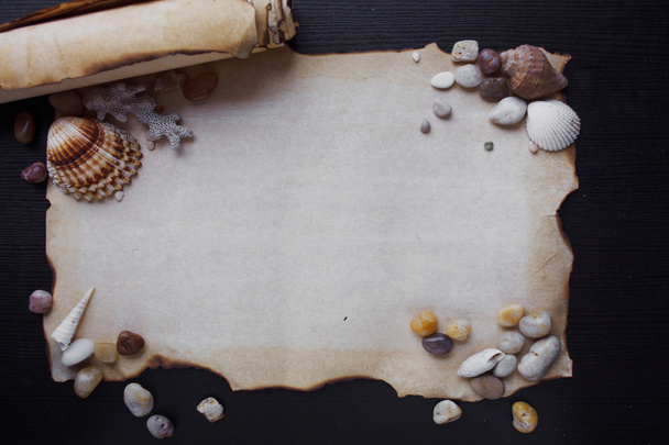 Old scroll of parchment with sea pebbles and seashells, nautical theme, place for text - Фото, изображение