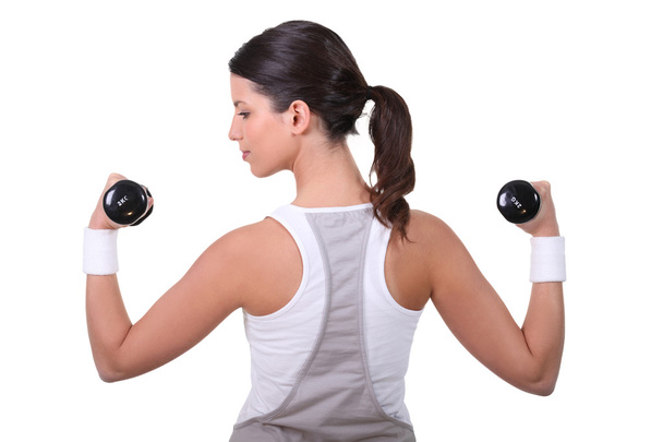 Woman working out with dumbbells - Foto, afbeelding