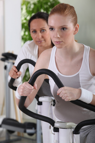 Mulheres usando máquinas de musculação no ginásio
 - Foto, Imagem