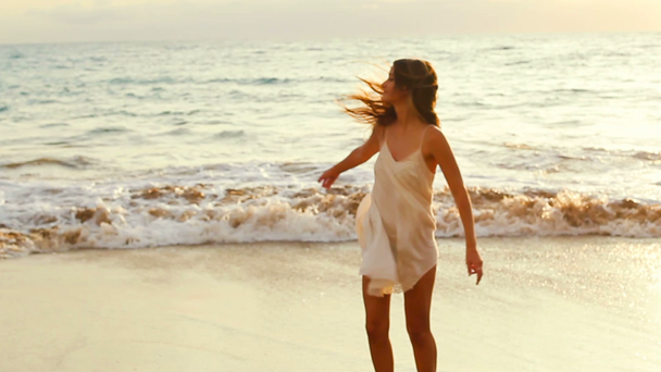 Mladá dívka se točí na pláži - Záběry, video