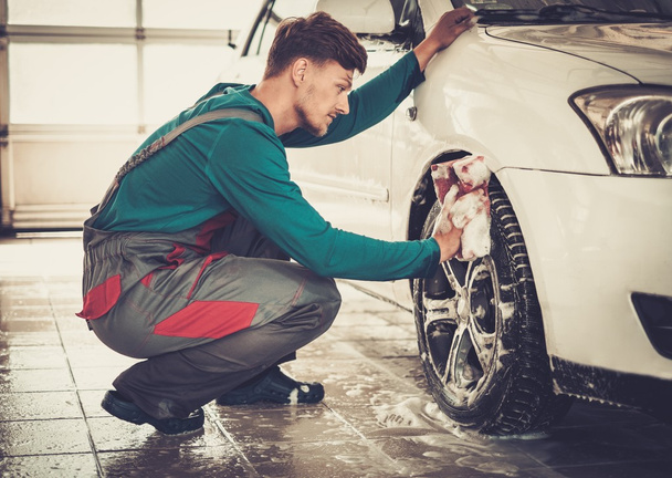 Man worker washing car's alloy rims - Foto, Bild