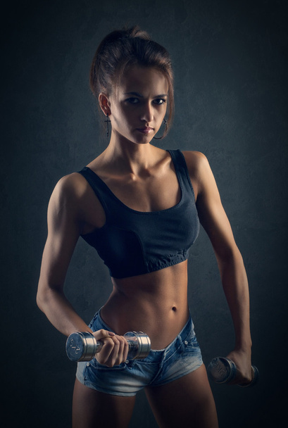 sporty girl doing exercise with dumbbells - Valokuva, kuva