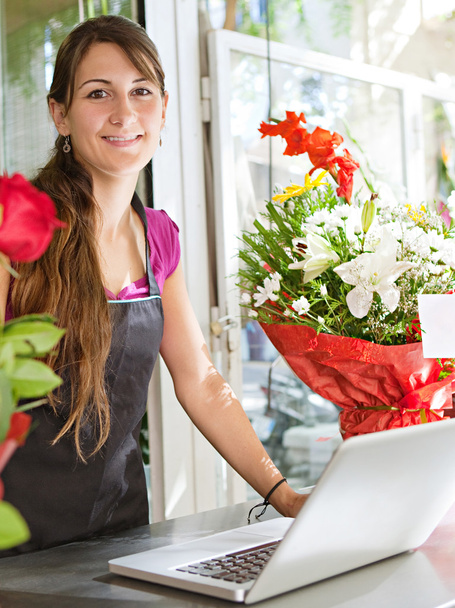Kwiaciarnia kobieta za pomocą laptopa w jej sklepie - Zdjęcie, obraz