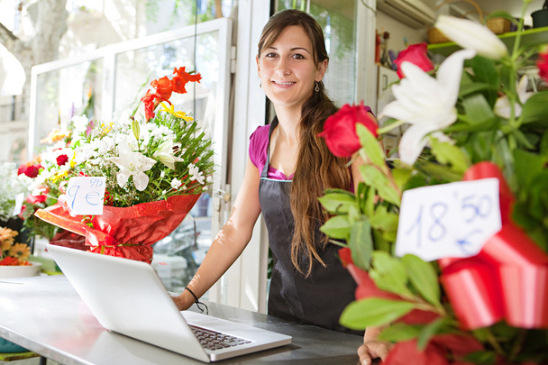 Kwiaciarnia kobieta za pomocą laptopa w jej sklepie - Zdjęcie, obraz