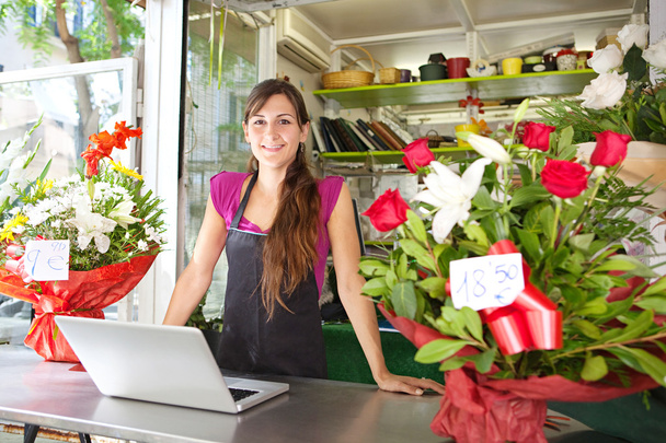 квіткова жінка використовує ноутбук у своєму магазині
 - Фото, зображення