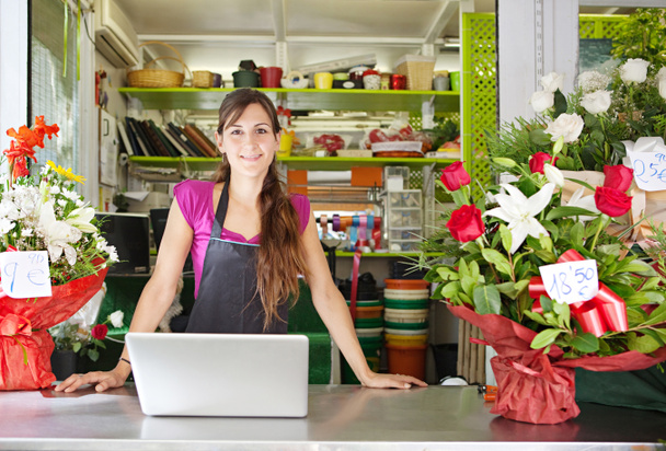fiorista donna utilizzando un computer portatile nel suo negozio
 - Foto, immagini