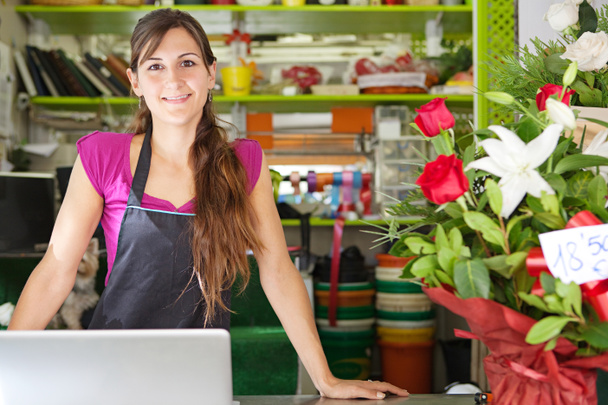 квіткова жінка використовує ноутбук у своєму магазині
 - Фото, зображення