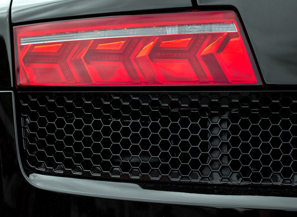 Close-up beeld van zwarte sportwagen achterlicht. - Foto, afbeelding