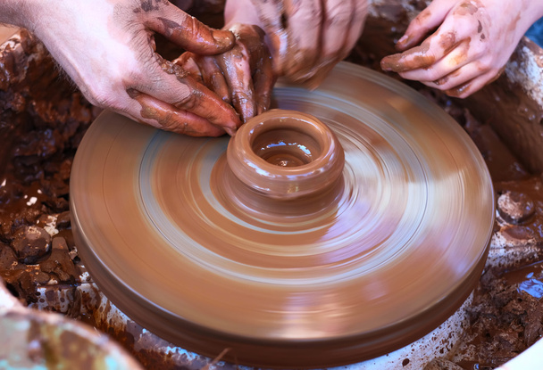Mani che lavorano sulla ruota della ceramica
 - Foto, immagini