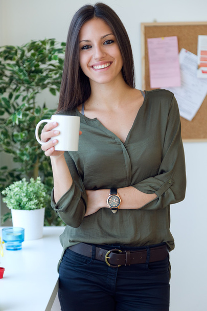 Business young woman drinking coffee in her office. - Fotoğraf, Görsel