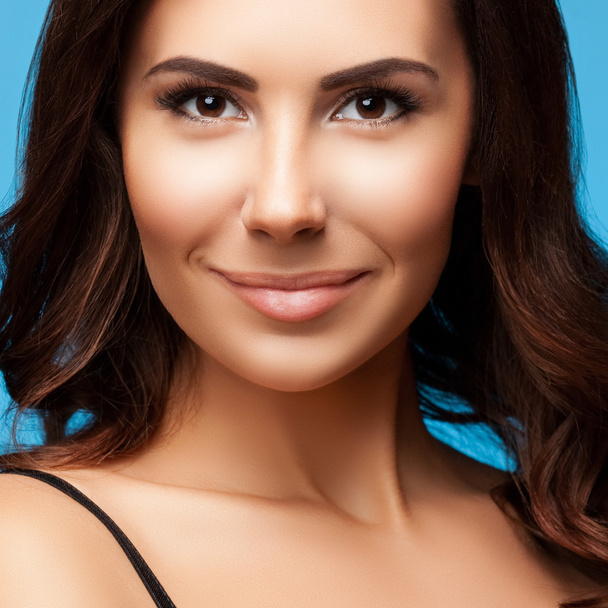 closeup portrait of beautiful young smiling woman, on blue - Photo, Image