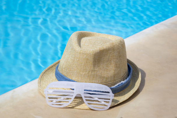 Chapeau de paille et lunettes de soleil de fête près de la piscine
 - Photo, image