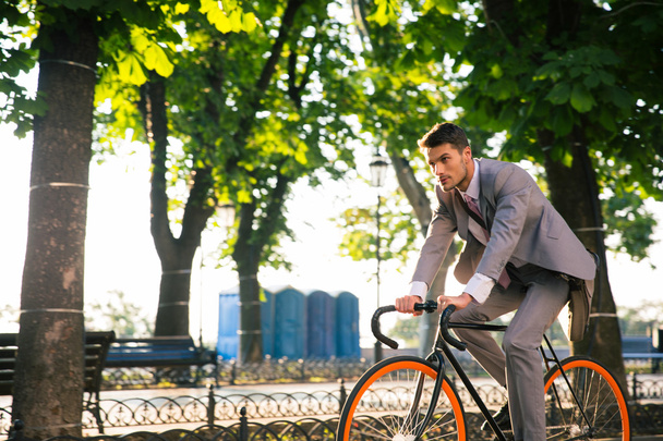 Businessman riding bicycle - Foto, afbeelding