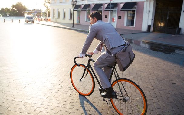 Businessman riding bicycle to work - Фото, изображение