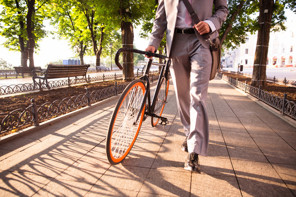 businessman walking with bicycle - Фото, изображение