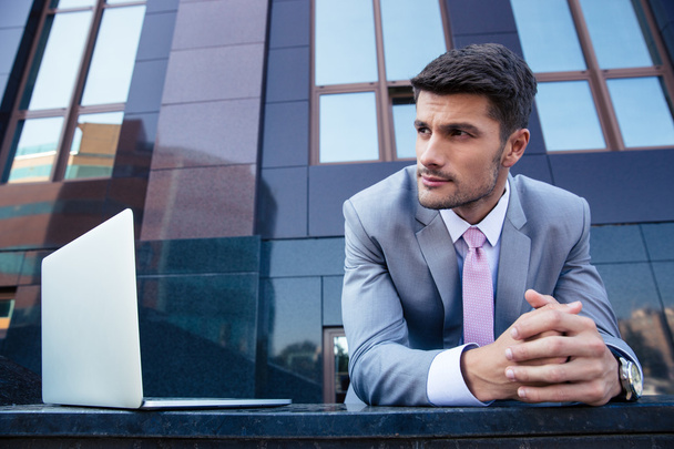 Businessman with laptop outdoors  - Foto, imagen