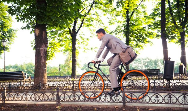 Businessman riding bicycle - Фото, зображення