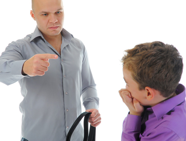 Strict father punishes his son - 写真・画像