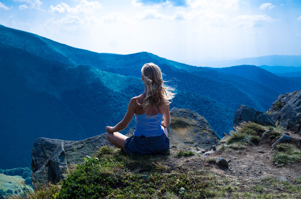 junge blonde Frau meditiert in der wunderschönen Berglandschaft - Foto, Bild