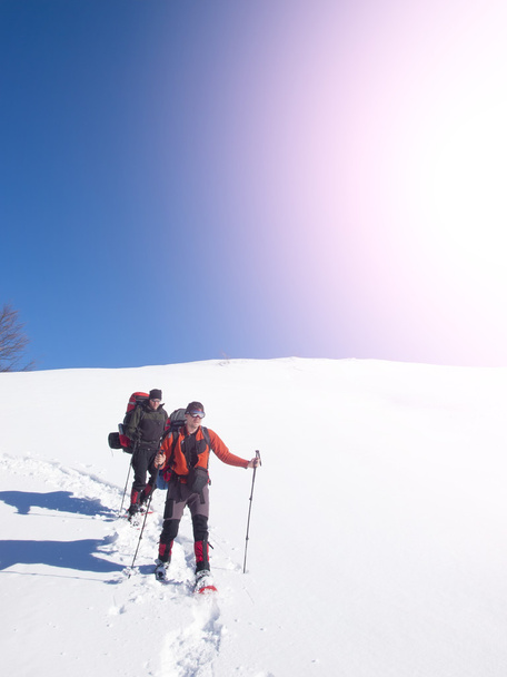 Los hombres van a raquetas de nieve en las montañas en la nieve
. - Foto, Imagen