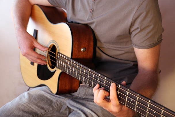 Young man playing on acoustic guitar - Фото, зображення