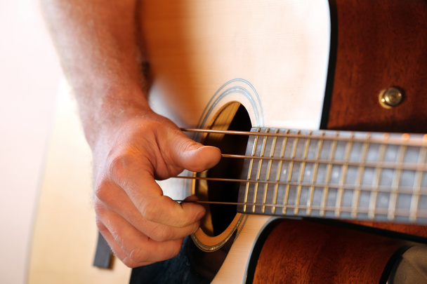 Young man playing on acoustic guitar close up - 写真・画像