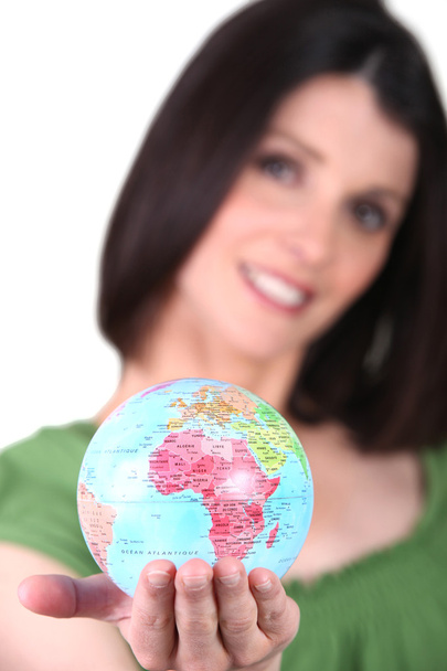 Woman holding a mini-globe - Fotoğraf, Görsel
