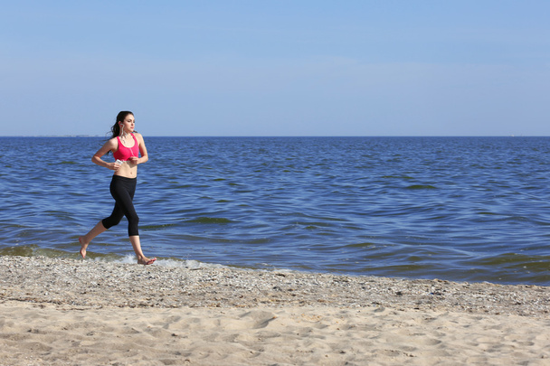 Jeune femme jogging sur la plage
 - Photo, image