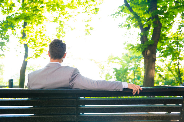 Businessman sitting on the bench outdoors - Photo, image