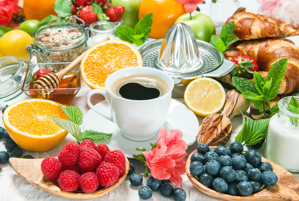 Coffee, croissants, granola, honey, yogurt, fresh berries, fruit - Photo, image