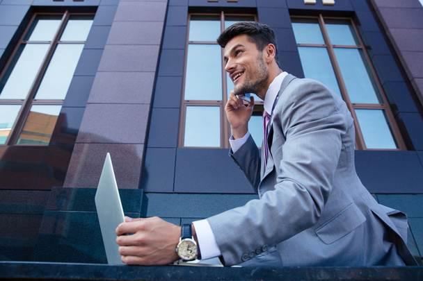 Businessman talking on the phone and using laptop  - Φωτογραφία, εικόνα