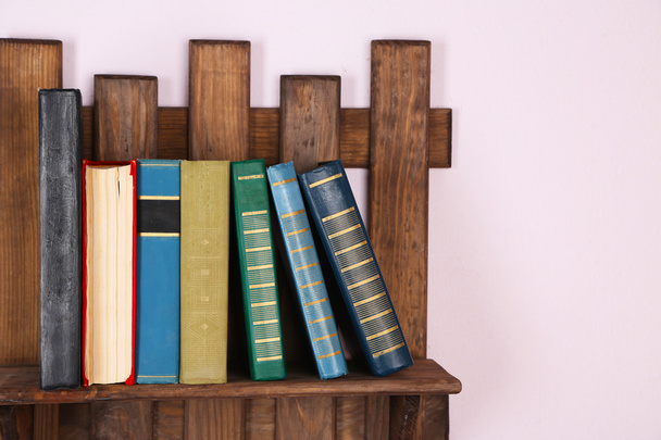 Wooden shelf with books on wall, closeup - Photo, Image