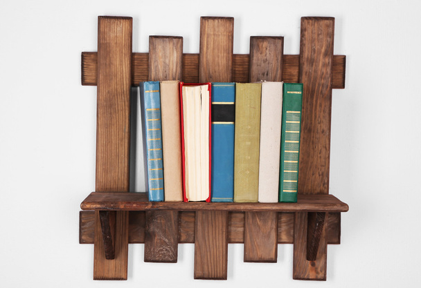 Wooden shelf with books on wall background - Φωτογραφία, εικόνα