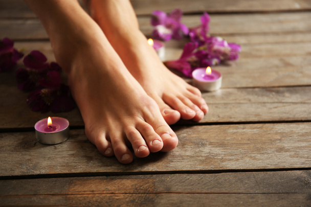 feet at spa pedicure procedure with flowers - Fotoğraf, Görsel