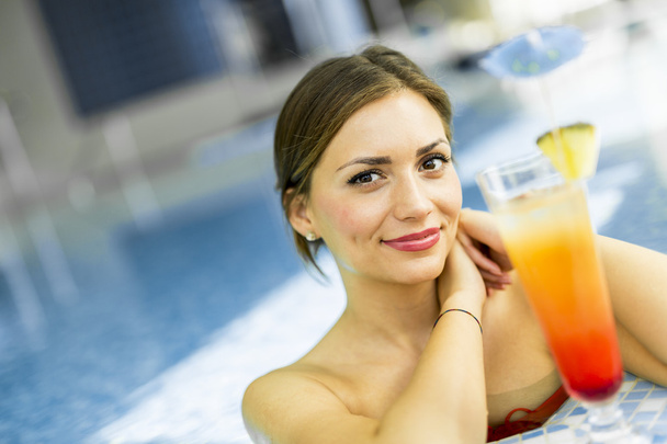 Beautiful woman in a pool with a cocktail - Photo, Image