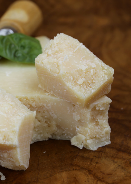 Кусок натурального сыра пармезан на деревянной доске
 - Фото, изображение