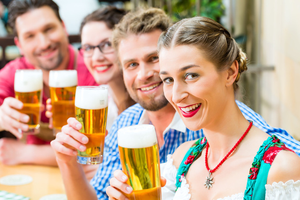 friends drinking beer in Bavarian restaurant or pub - Photo, Image