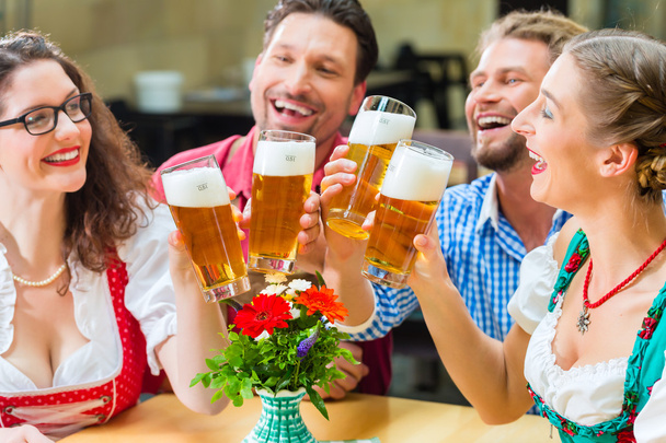 amigos bebiendo cerveza en el restaurante o pub bávaro
 - Foto, imagen