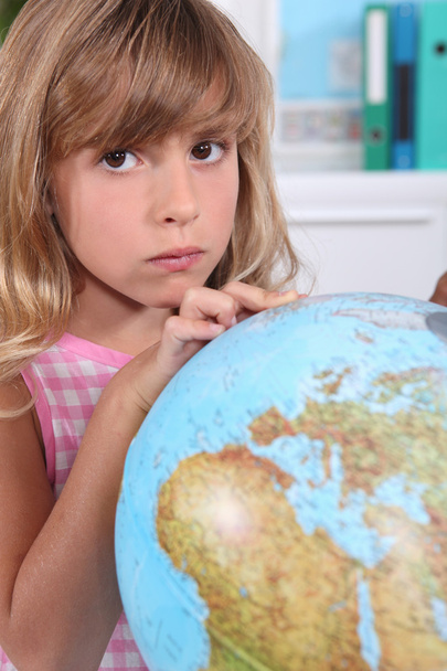 Girl looking at a large globe - Foto, afbeelding