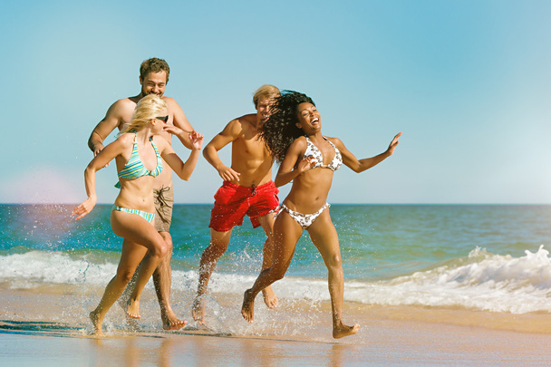Amigos correndo em férias na praia
 - Foto, Imagem