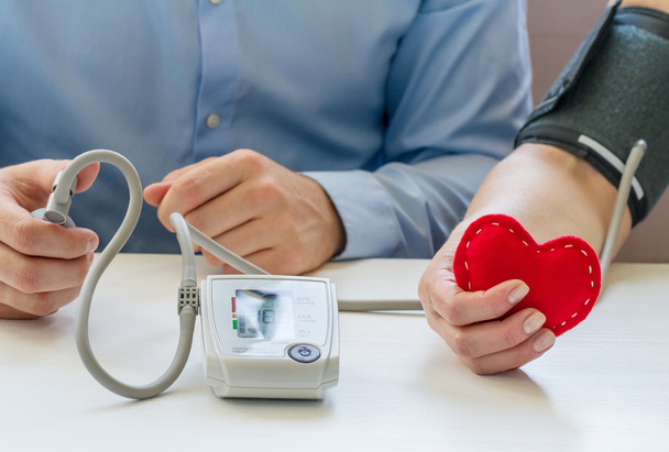 Médico que mede a pressão arterial
 - Foto, Imagem