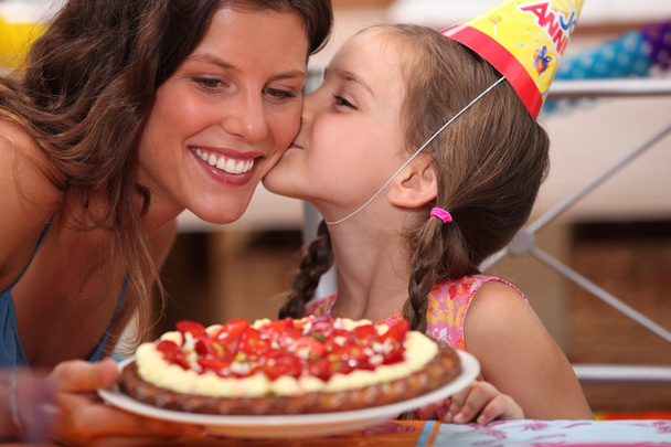 Daughter kissing mommy at birthday party - Photo, Image