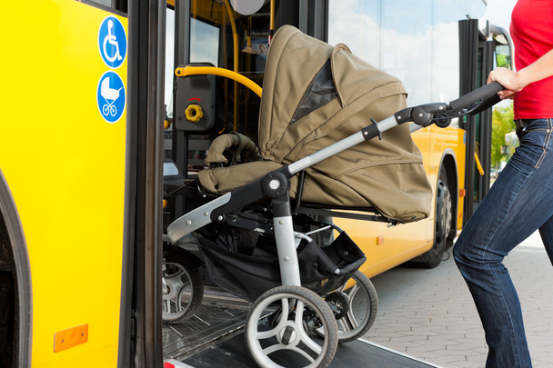 Женщина с коляской садится в автобус
 - Фото, изображение