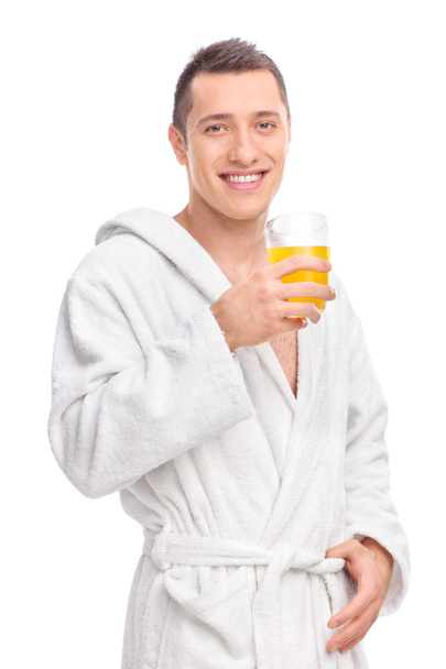 Man in bathrobe holding orange juice - Fotoğraf, Görsel