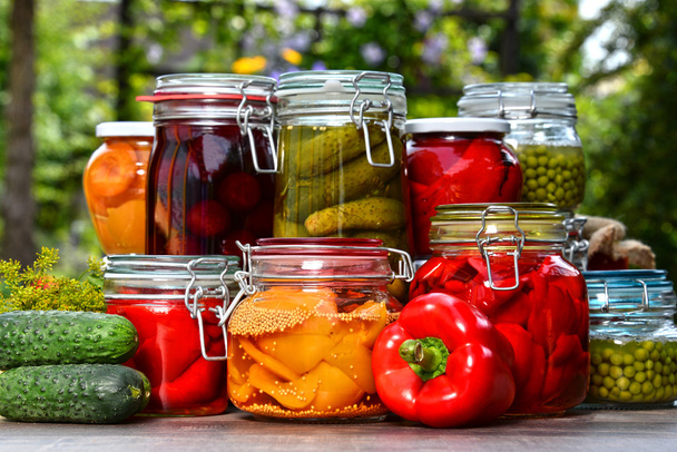 Jars of pickled vegetables and fruits in the garden - Foto, Imagen