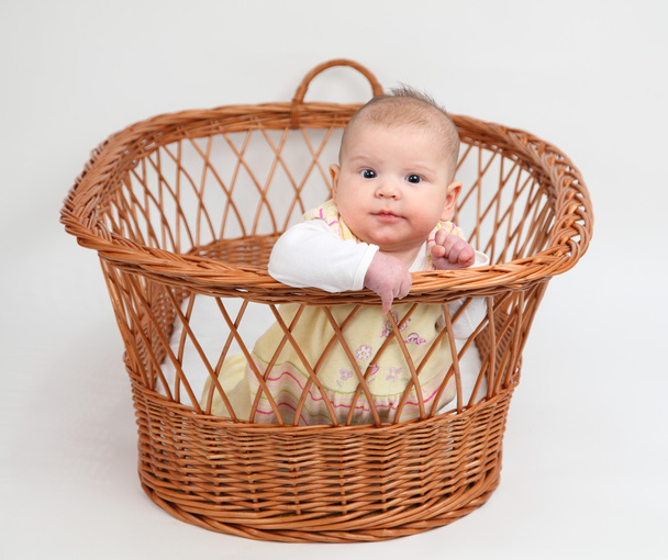 Little baby girl sitting in basket - Fotó, kép